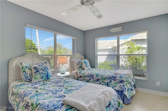 bedroom featuring ceiling fan, light tile patterned flooring, and multiple windows