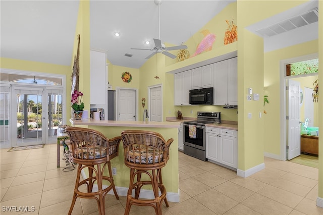 kitchen with stainless steel range with electric stovetop, white cabinetry, kitchen peninsula, and light tile patterned floors