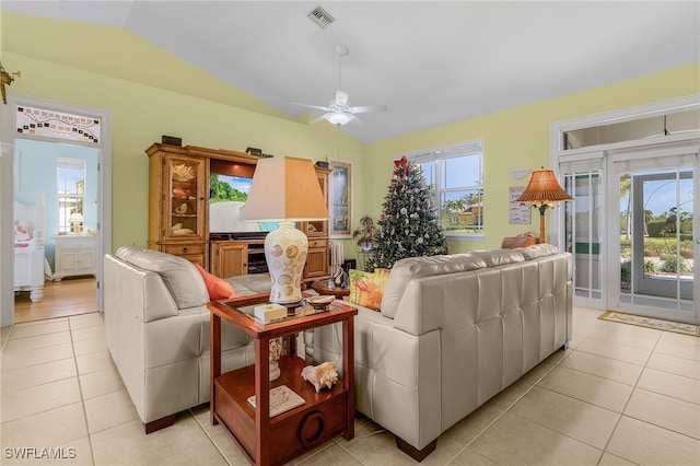 living room featuring ceiling fan, light tile patterned floors, and lofted ceiling