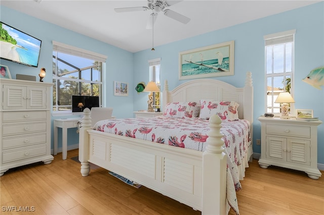 bedroom with ceiling fan, light wood-type flooring, and multiple windows