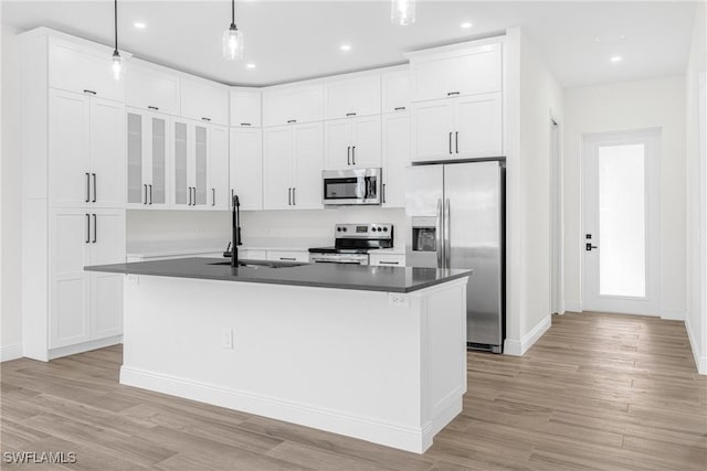 kitchen featuring pendant lighting, sink, an island with sink, light hardwood / wood-style floors, and stainless steel appliances