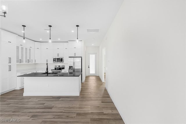 kitchen with pendant lighting, white cabinets, light wood-type flooring, and stainless steel appliances