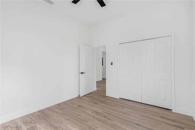 unfurnished bedroom featuring a closet, light hardwood / wood-style flooring, and ceiling fan