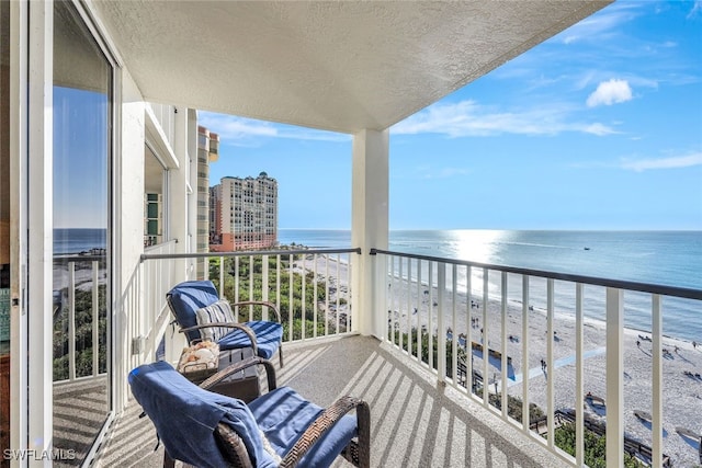 balcony with a beach view and a water view