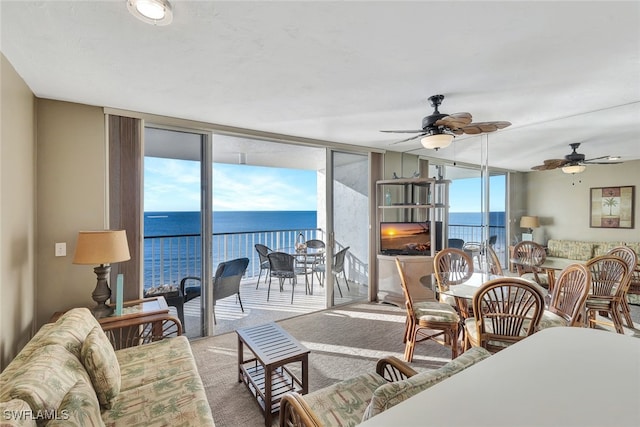 carpeted living room with ceiling fan, a healthy amount of sunlight, and floor to ceiling windows