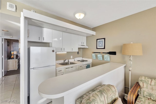 kitchen with white cabinetry, sink, kitchen peninsula, white appliances, and light tile patterned floors