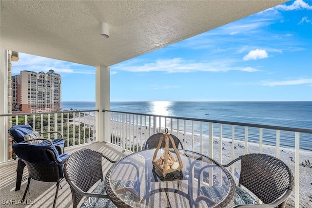 balcony with a water view and a beach view