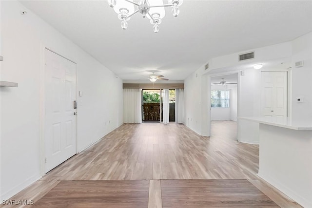 entryway featuring ceiling fan with notable chandelier and light wood-type flooring