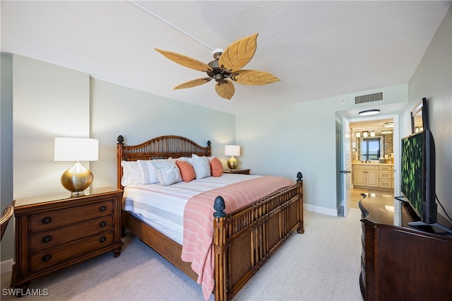 bedroom with ensuite bathroom, ceiling fan, and light colored carpet