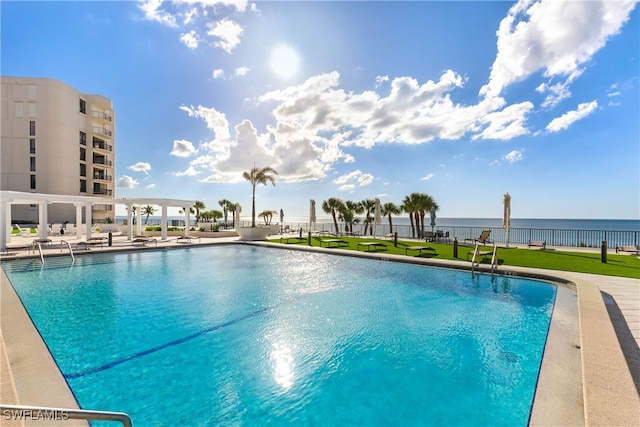 view of swimming pool featuring a water view and a patio