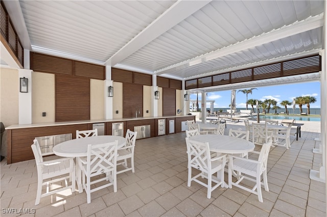 view of patio featuring area for grilling, a water view, and a community pool