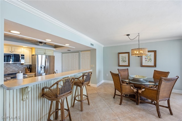 tiled dining space with an inviting chandelier and crown molding