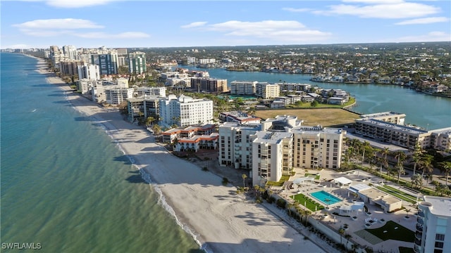 birds eye view of property featuring a water view and a beach view