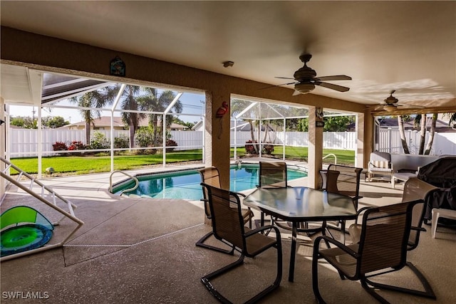 view of swimming pool featuring a lanai, a patio area, ceiling fan, and a lawn