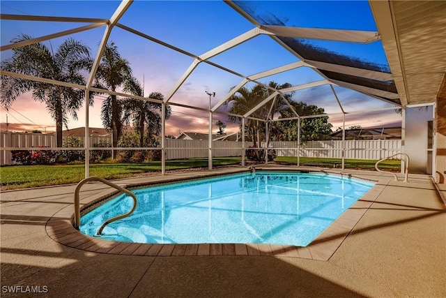 pool at dusk featuring a lanai and a patio area