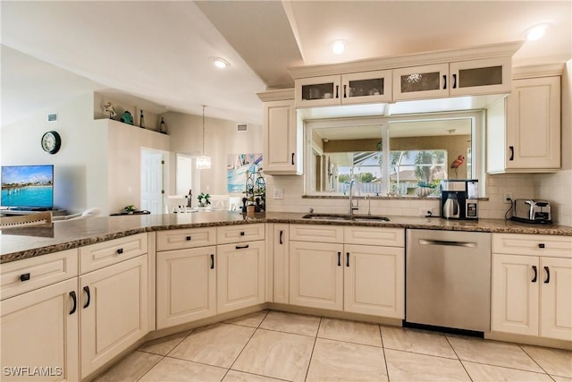 kitchen with sink, decorative backsplash, vaulted ceiling, and stainless steel dishwasher