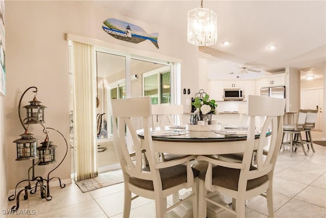 dining area featuring light tile patterned floors and ceiling fan with notable chandelier