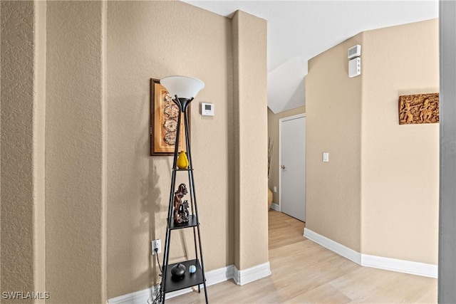 hallway featuring light wood-type flooring and baseboards