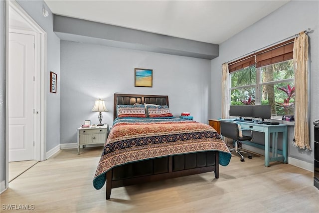 bedroom with light wood-style flooring and baseboards