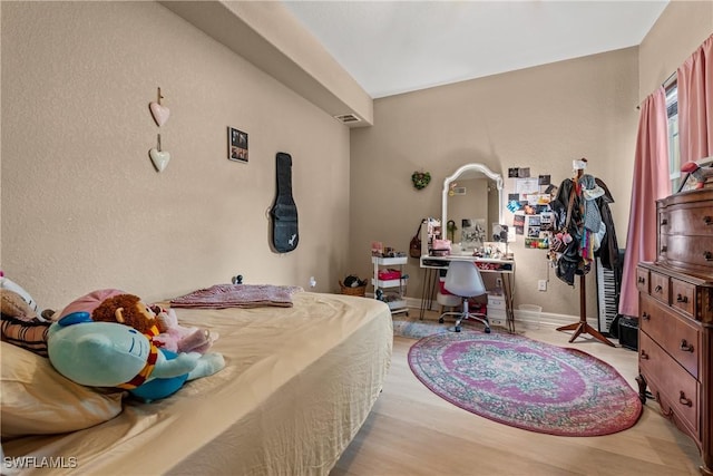 bedroom with light wood-type flooring, baseboards, and visible vents