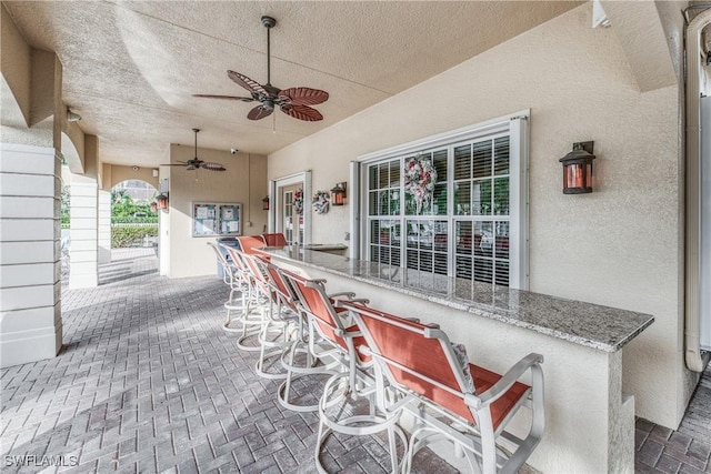 view of patio / terrace with ceiling fan and exterior bar