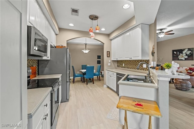 kitchen with decorative light fixtures, stainless steel appliances, visible vents, light countertops, and white cabinets