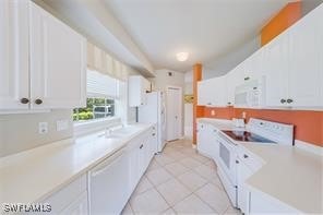 kitchen featuring white cabinets, light tile patterned floors, white appliances, and washer / clothes dryer