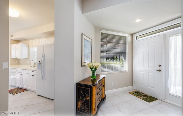 entryway with light tile patterned floors and baseboards