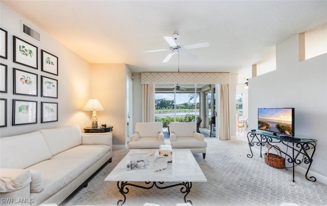 carpeted living room featuring a ceiling fan, visible vents, and baseboards