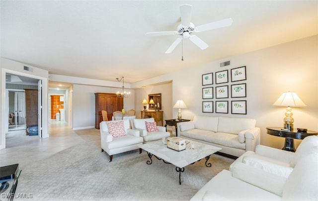 living area with ceiling fan with notable chandelier and visible vents