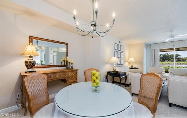 dining area featuring light carpet and ceiling fan with notable chandelier