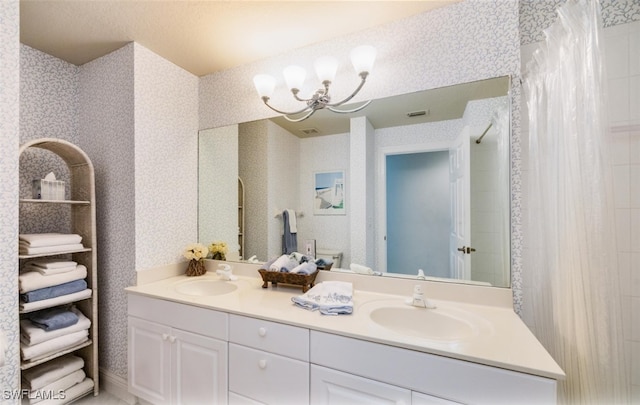 full bathroom with double vanity, a sink, and wallpapered walls