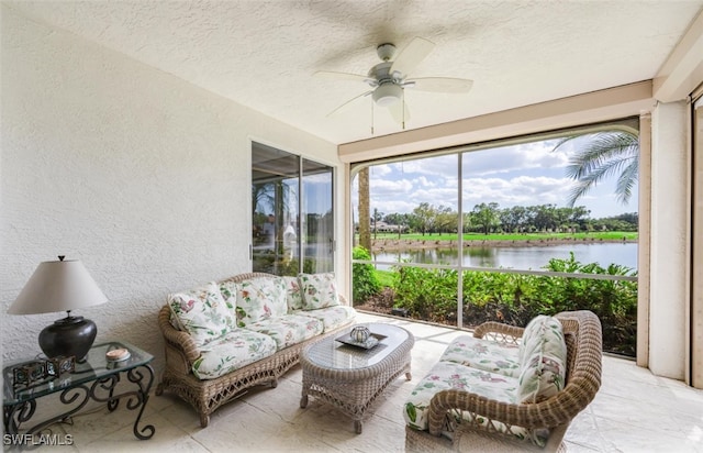 sunroom featuring a water view and a ceiling fan