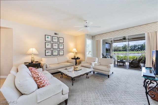 living area with carpet floors, baseboards, visible vents, and a ceiling fan