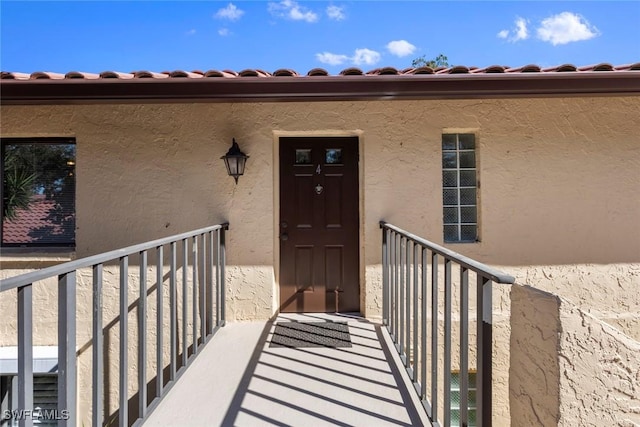 view of exterior entry with a balcony