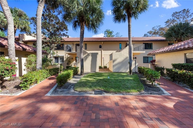 mediterranean / spanish-style house with a front yard