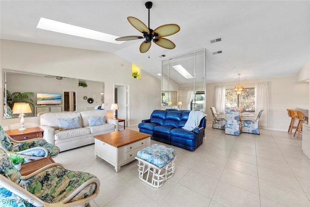 tiled living room featuring ceiling fan and vaulted ceiling with skylight