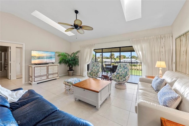 tiled living room with lofted ceiling with skylight and ceiling fan