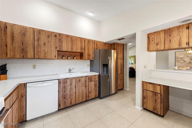 kitchen featuring sink, stainless steel refrigerator with ice dispenser, a towering ceiling, white dishwasher, and light tile patterned floors