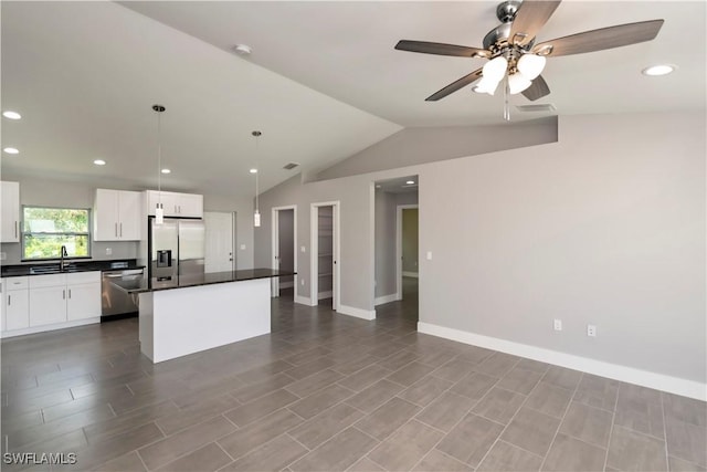 kitchen with white cabinets, vaulted ceiling, ceiling fan, decorative light fixtures, and stainless steel appliances