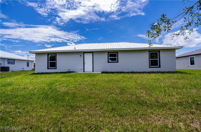 back of house featuring a lawn and cooling unit