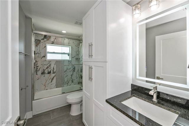 full bathroom featuring tile patterned flooring, vanity, bath / shower combo with glass door, and toilet