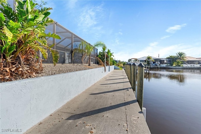 dock area with a lanai and a water view