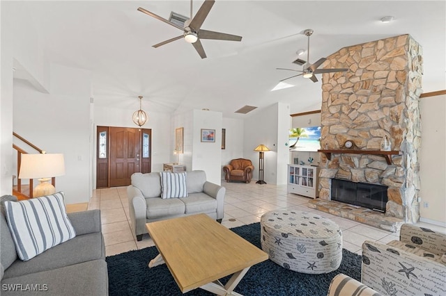 living room featuring a fireplace, ceiling fan with notable chandelier, lofted ceiling, and light tile patterned flooring