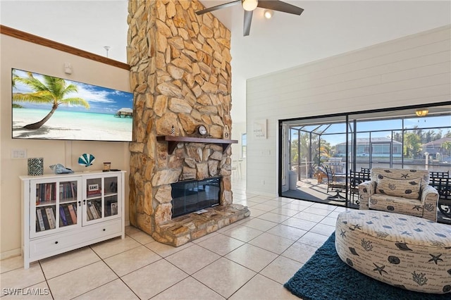 unfurnished living room featuring a stone fireplace, ceiling fan, high vaulted ceiling, and light tile patterned floors