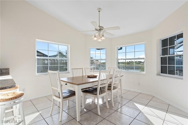 tiled dining area with vaulted ceiling, a wealth of natural light, and ceiling fan