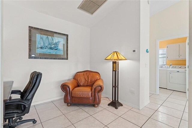 office area with washing machine and dryer, light tile patterned floors, and vaulted ceiling