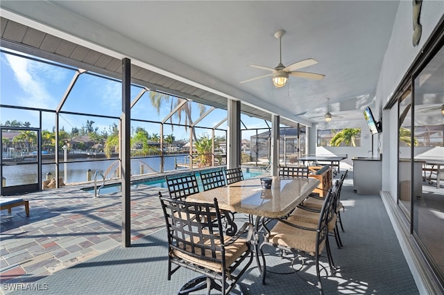 sunroom with ceiling fan, a healthy amount of sunlight, and a water view