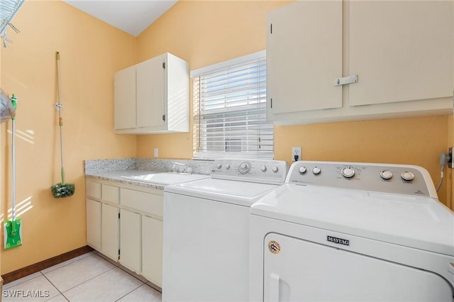 laundry area with cabinets, light tile patterned floors, separate washer and dryer, and sink