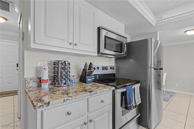 kitchen with appliances with stainless steel finishes, light tile patterned floors, white cabinetry, and crown molding